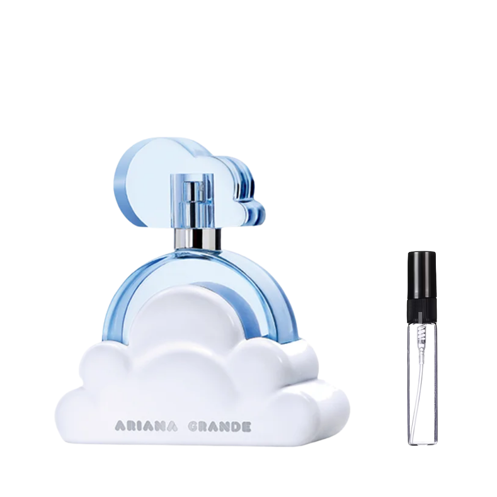 Jasnoniebieski flakon perfum Ariana Grande Cloud w kształcie okręgu na białej podstawie przypominającej chmurę z niebieskim korkiem, obok którego znajduje się przezroczysta, szklana fiolka odlewki z czarnym atomizerem. – ODVARO