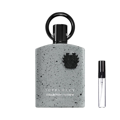 Jasnoszary flakon perfum Afnan Supremacy Collector's Edition w czarne kropki, ze złotymi napisami, czarnym emblematem i charakterystycznym korkiem z pierścieniem oraz szklana fiolka odlewki – ODVARO.