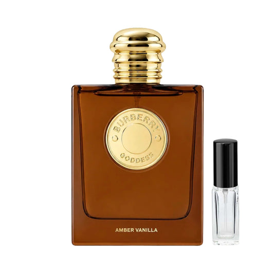 Kwadratowy, bursztynowy flakon perfum Burberry Goddess Amber Vanilla ze złotym, okrągłym emblematem i prążkowanym korkiem, obok którego znajduje się szklana fiolka odlewki – ODVARO.