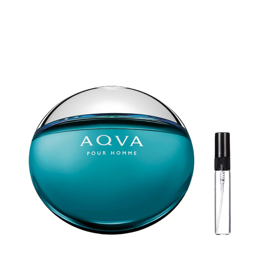 Okrągły, spłaszczony flakon perfum Bvlgari Aqva Pour Homme przypominający gładki kamień morski w odcieniu morskiej zieleni z chromowaną, srebrną górą, prezentowany obok szklanej fiolki odlewki – ODVARO