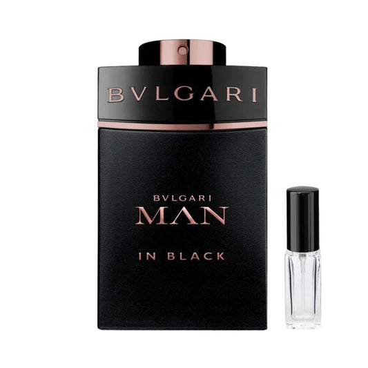 Czarny, matowy flakon męskich perfum Bvlgari Man In Black z miedziano-złotymi napisami oraz metalicznym detalem pod czarnym atomizerem, a obok niego szklana fiolka odlewki – ODVARO.