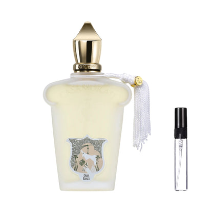 Matowy flakon perfum Casamorati 1888 Dama Bianca w stylu vintage, ze złotym spiczastym korkiem, białą ozdobną kitką, etykietą z profilem kobiety oraz szklana fiolka odlewki – ODVARO.