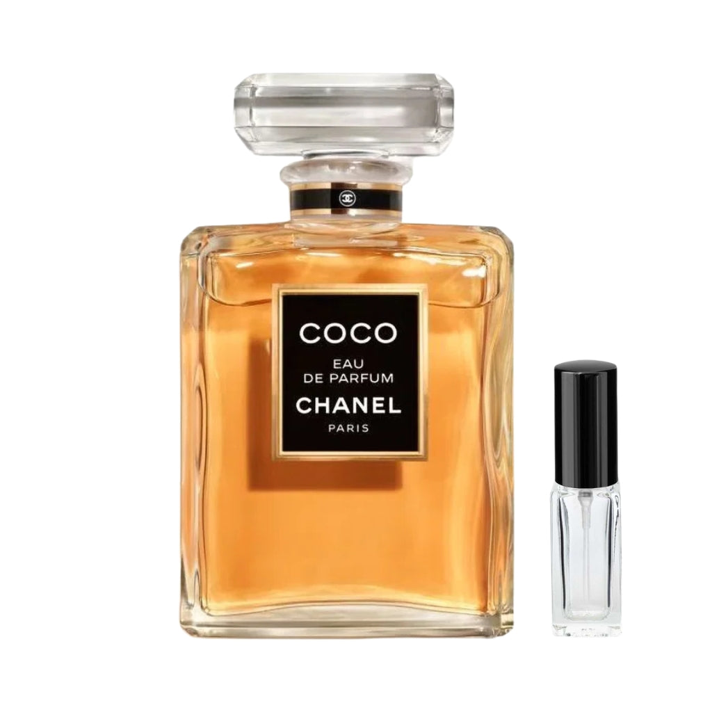 Szklany, klasyczny flakon damskich perfum Coco Eau de Parfum Chanel wypełniony bursztynowym płynem, z prostokątną czarną etykietą ze złotą ramką i przezroczystym, fasetowanym korkiem ozdobionym czarno-złotą opaską, a obok niego szklana fiolka odlewki – ODVARO.