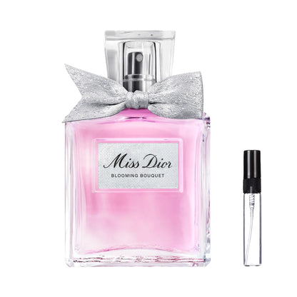 Prostokątny, szklany flakon Miss Dior Blooming Bouquet z różowym płynem, ozdobną materiałową kokardką i przezroczystym korkiem oraz szklana fiolka odlewki – ODVARO.