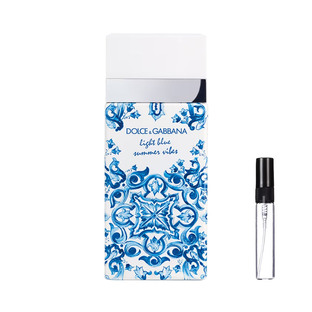 Prostokątny flakon perfum Dolce&Gabbana Light Blue Summer Vibes ozdobiony niebiesko-białym wzorem majoliki, ze srebrnym detalem i gładkim białym korkiem, a obok widoczna szklana fiolka odlewki – ODVARO.