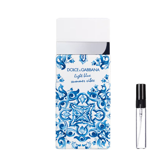 Prostokątny flakon perfum Dolce&Gabbana Light Blue Summer Vibes ozdobiony niebiesko-białym wzorem majoliki, ze srebrnym detalem i gładkim białym korkiem, a obok widoczna szklana fiolka odlewki – ODVARO.