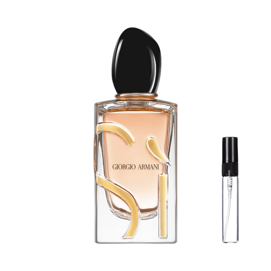 Elegancki, przezroczysty flakon Giorgio Armani Si z brzoskwiniowym płynem, złotym napisem i czarnym, obłym korkiem obok smukłej szklanej fiolki odlewki perfum – ODVARO