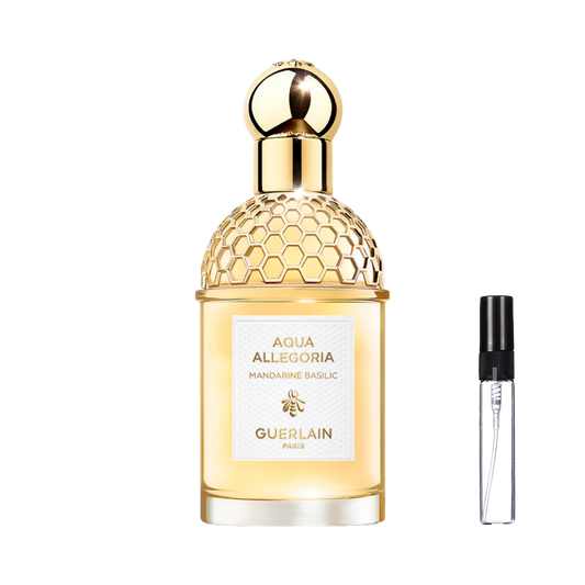 Cylindryczny flakon ze złotą siateczką w kształcie plastra miodu i kulistym korkiem, wypełniony złocistym płynem, obok szklana fiolka odlewki na perfumy – ODVARO