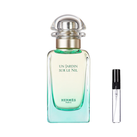 Elegancki flakon Hermès Un Jardin Sur Le Nil z charakterystycznym zielono-żółtym gradientem i przezroczystym, obłym korkiem obok smukłej szklanej fiolki odlewki – ODVARO
