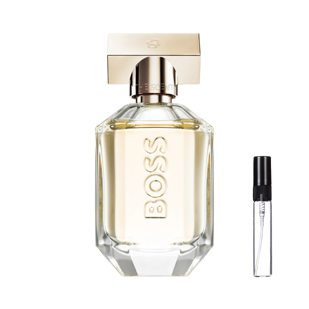 Oszlifowany, szklany flakon perfum Hugo Boss The Scent For Her ze żłobieniami, wypełniony brzoskwiniowym płynem. Na froncie widnieje klasyczne logo, a całość wieńczy duży, geometryczny złoty korek. W ofercie dostępna również poręczna szklana fiolka odlewki – ODVARO