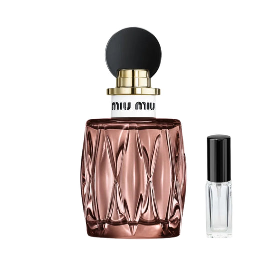 Pikowany, metaliczny flakon perfum Miu Miu Miutine w odcieniu różowego złota z białym kołnierzem i okrągłym, czarnym korkiem. Obok elegancka, szklana fiolka z odlewką. – ODVARO