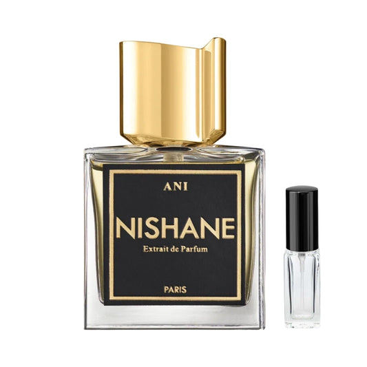Przezroczysty, kwadratowy flakon perfum Nishane Ani z elegancką, czarną etykietą ze złotymi napisami i wyrazistym, asymetrycznym złotym korkiem, obok szklana fiolka odlewki – ODVARO.