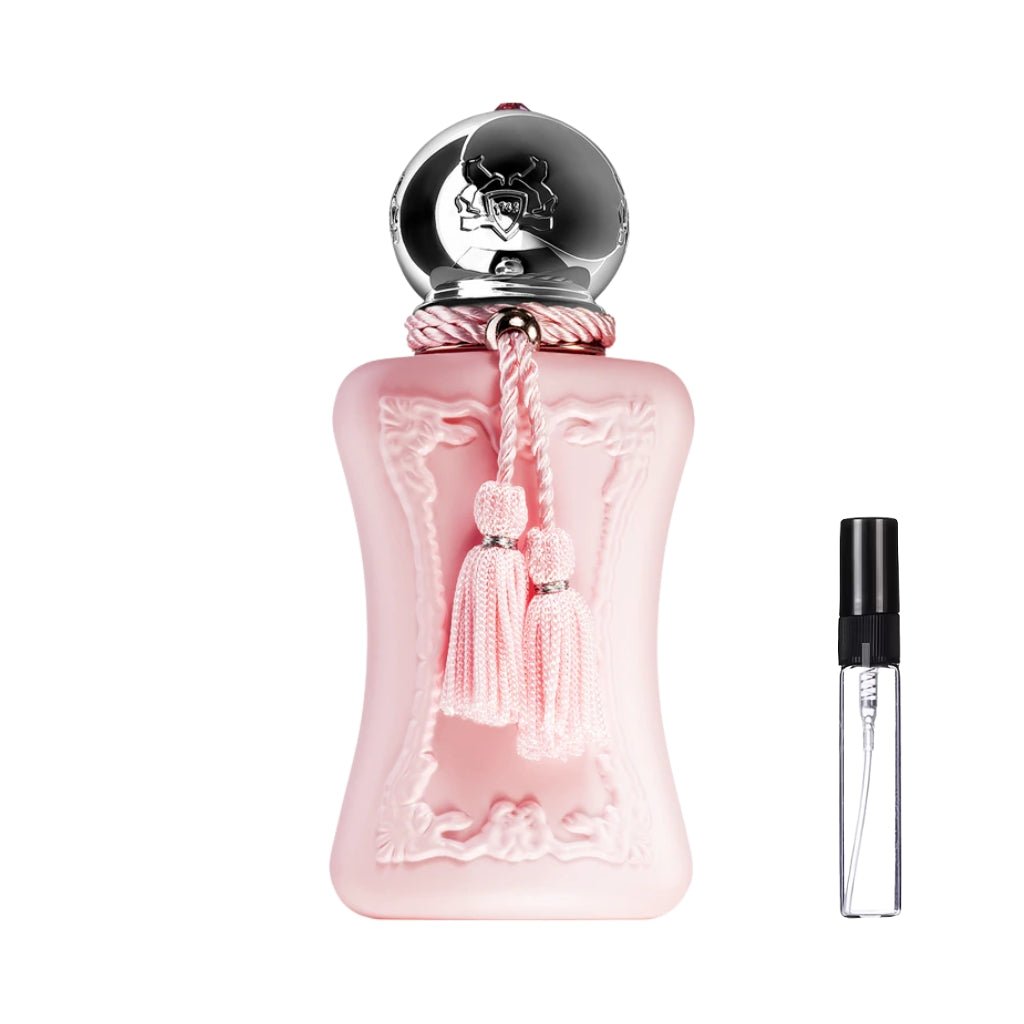 Pasteloworóżowy flakon perfum Parfums de Marly Delina z eleganckimi rzeźbieniami, okrągłym, srebrnym korkiem i ozdobnymi chwostami, zaprezentowany obok szklanej fiolki odlewki – ODVARO