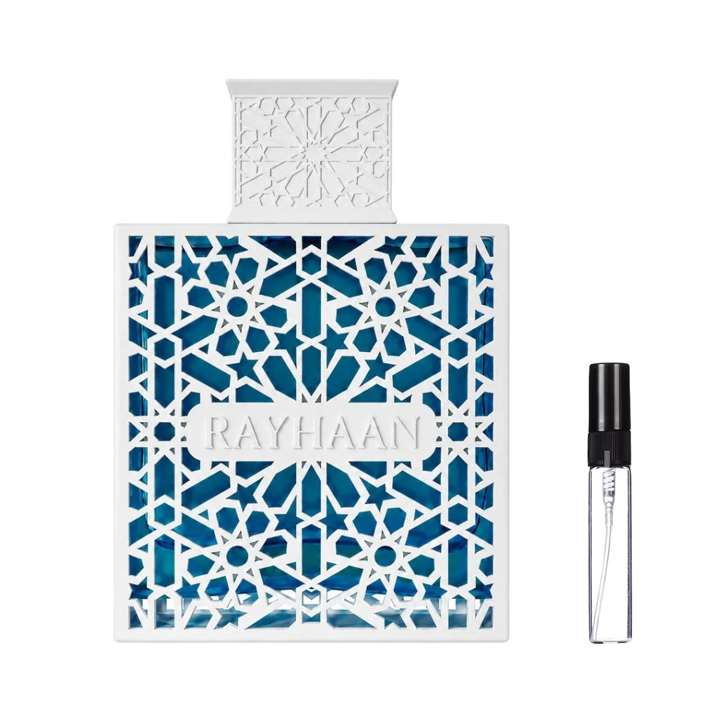 Kwadratowy flakon perfum Rayhaan Azul z niebieskim szkłem i elegancką, białą ażurową obudową ze wschodnim wzorem, obok szklana fiolka odlewki – ODVARO.