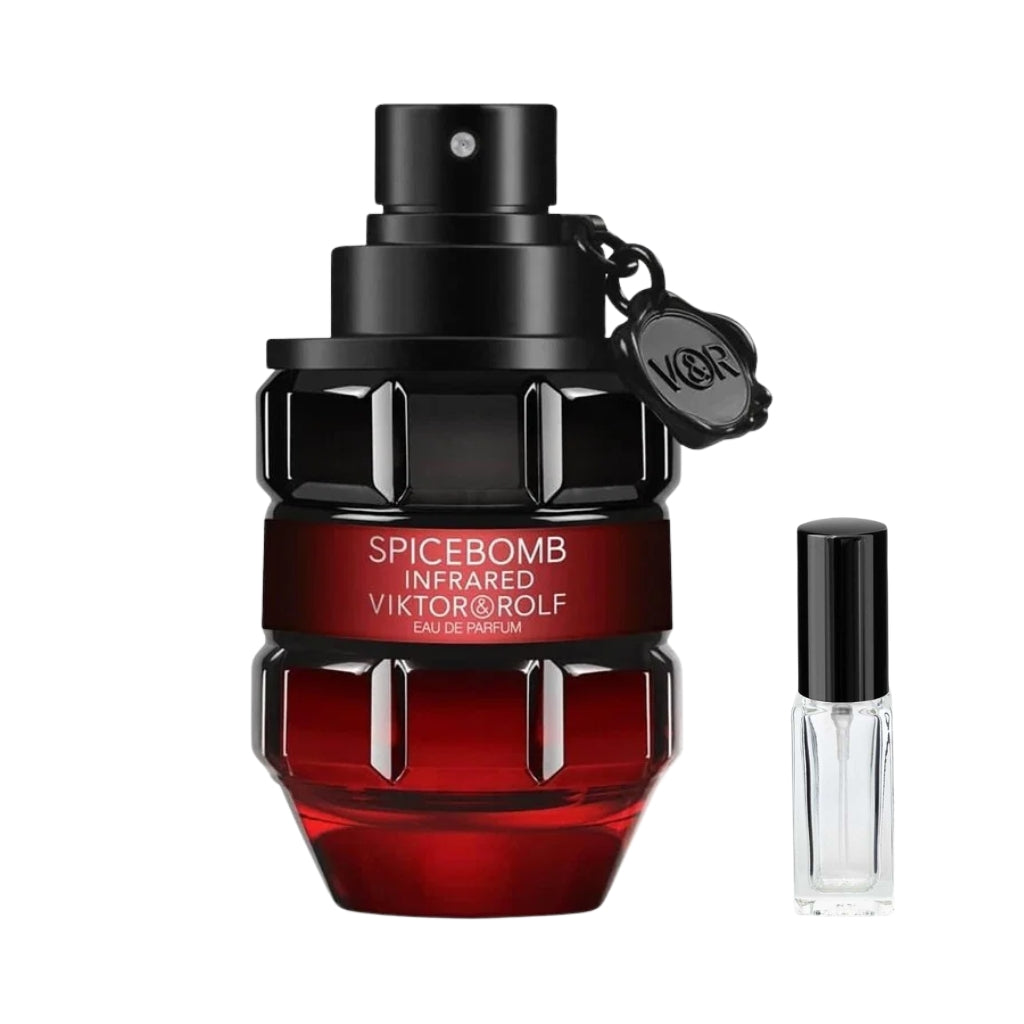 Szklany flakon męskich perfum Spicebomb Infrared Viktor&Rolf w kształcie granatu, łączący czerń u góry z półprzezroczystą czerwienią u podstawy, z czarną opaską z nazwą zapachu i zawleczką, a obok niego szklana fiolka odlewki – ODVARO.