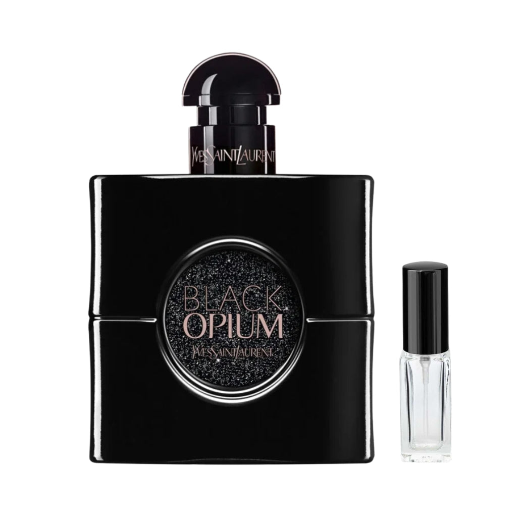 Kwadratowy, całkowicie czarny flakon damskich perfum Black Opium Le Parfum Yves Saint Laurent z okrągłym, połyskującym brokatem detalem na froncie i półokrągłym korkiem, a obok niego szklana fiolka odlewki – ODVARO.