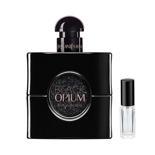Kwadratowy, całkowicie czarny flakon damskich perfum Black Opium Le Parfum Yves Saint Laurent z okrągłym, połyskującym brokatem detalem na froncie i półokrągłym korkiem, a obok niego szklana fiolka odlewki – ODVARO.